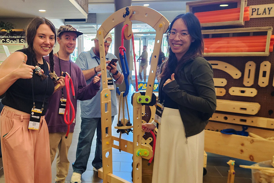 Conference attendees give two thumbs up at Serious Play Conference at St. John Fisher University.