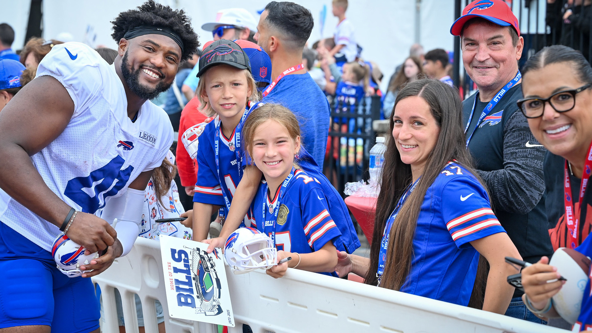 NFL players of the Buffalo Bills sign footballs for fans at St. John Fisher University.