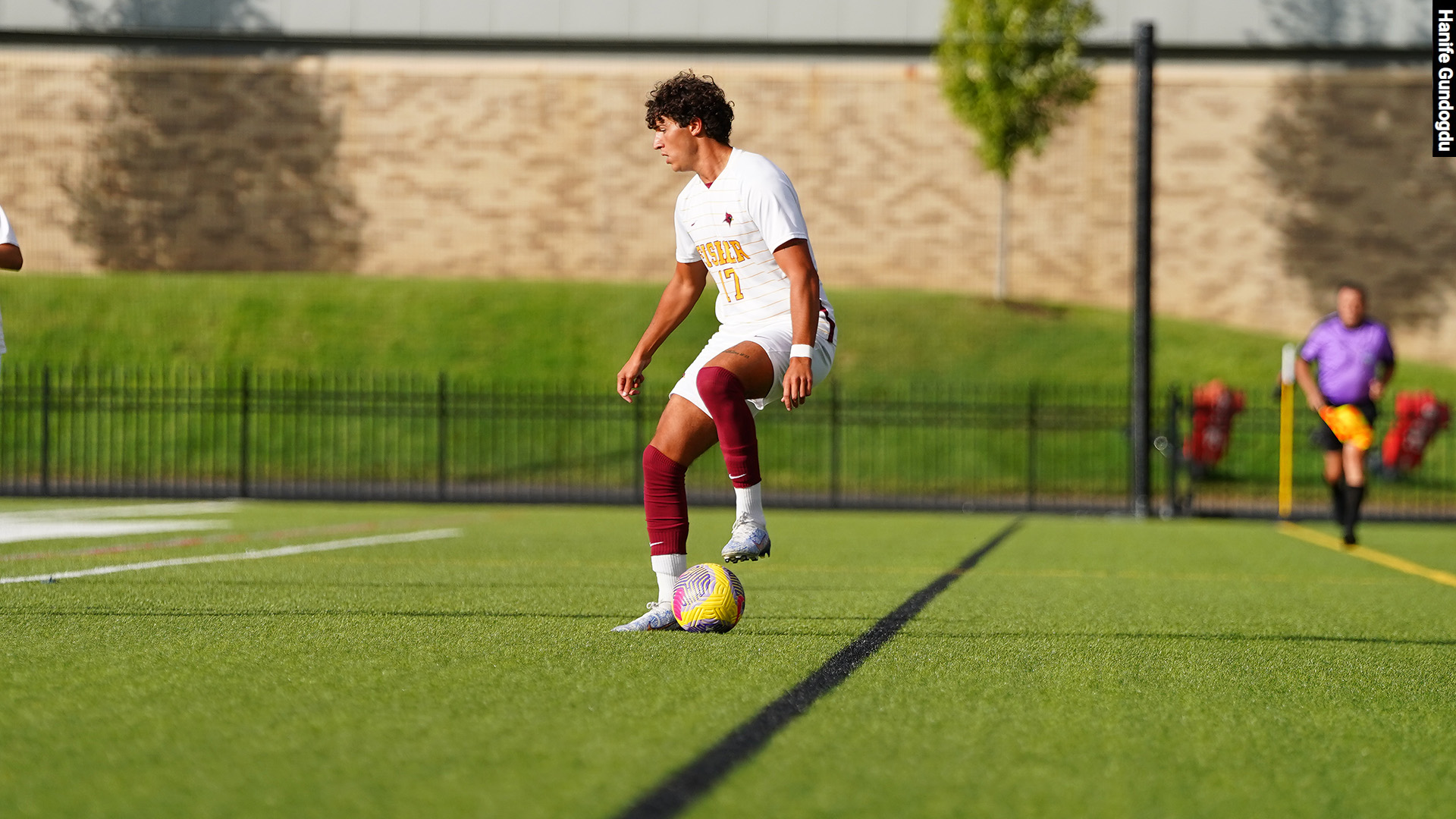A Fisher soccer player traps the ball on the field.