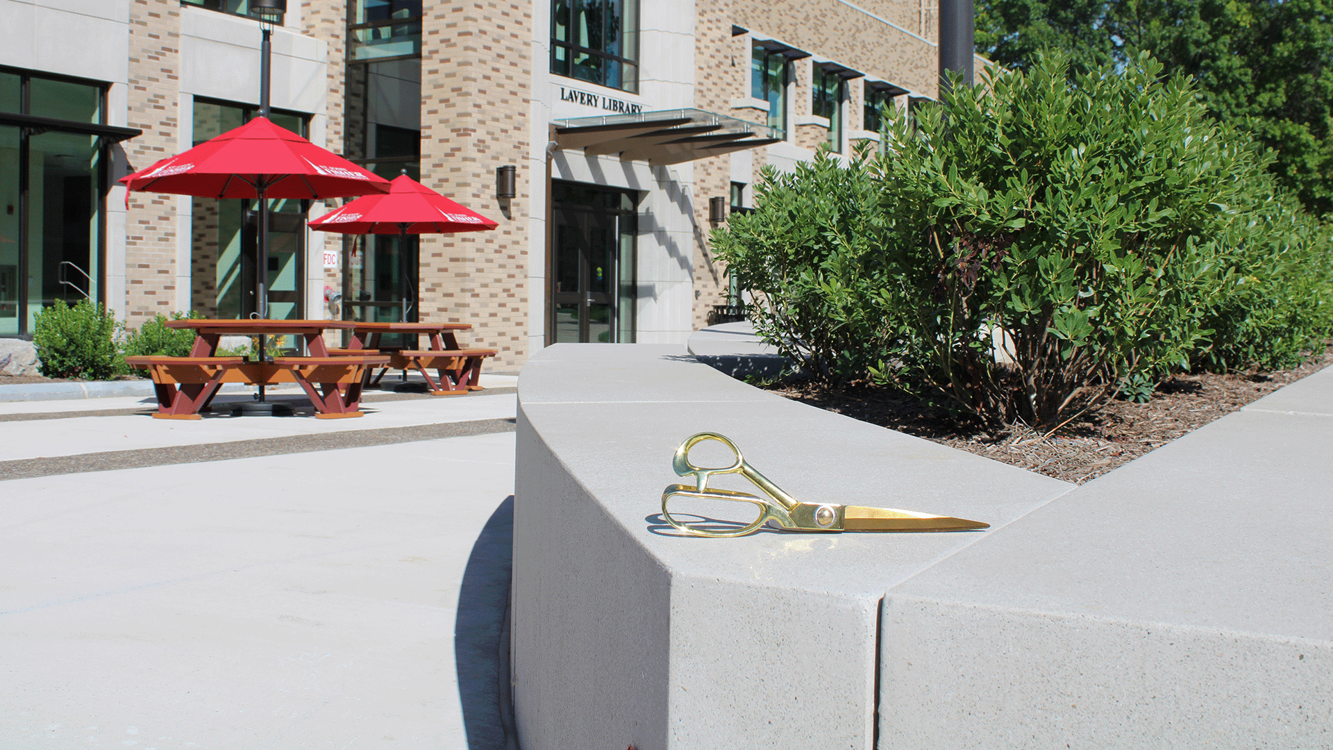 Gold ribbon cutting scissors in front of Lavery Library preparing for the Grand Reopening.