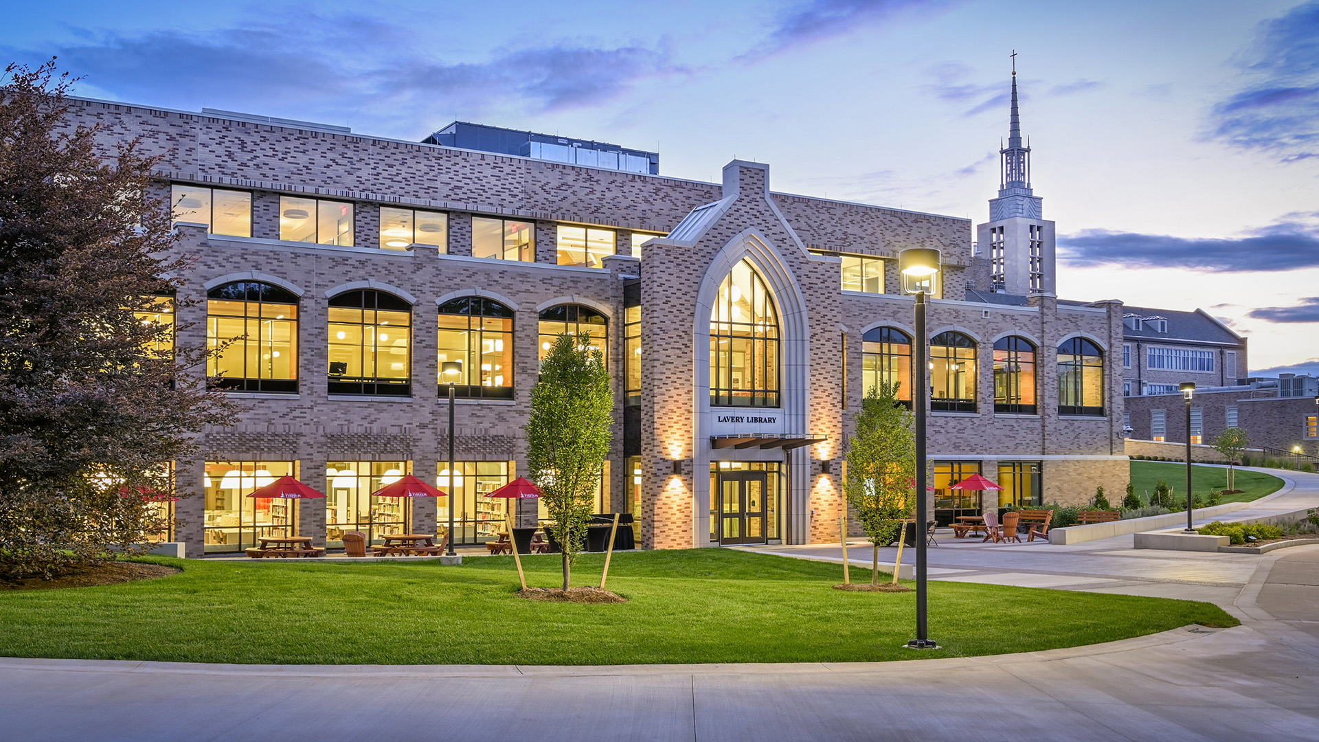 Lavery Library brightly lit in the evening with iconic Kearney Hall as a backdrop.