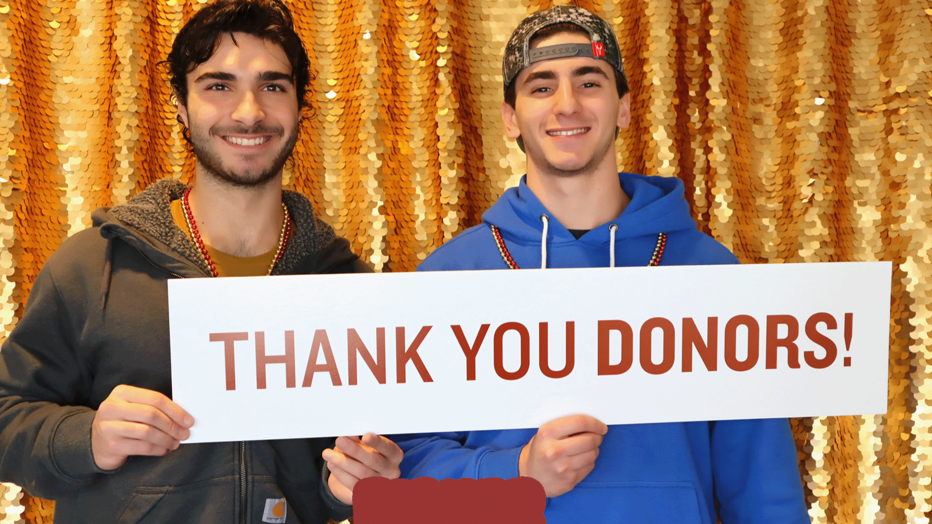 Students hold a sign with text thank you donors.
