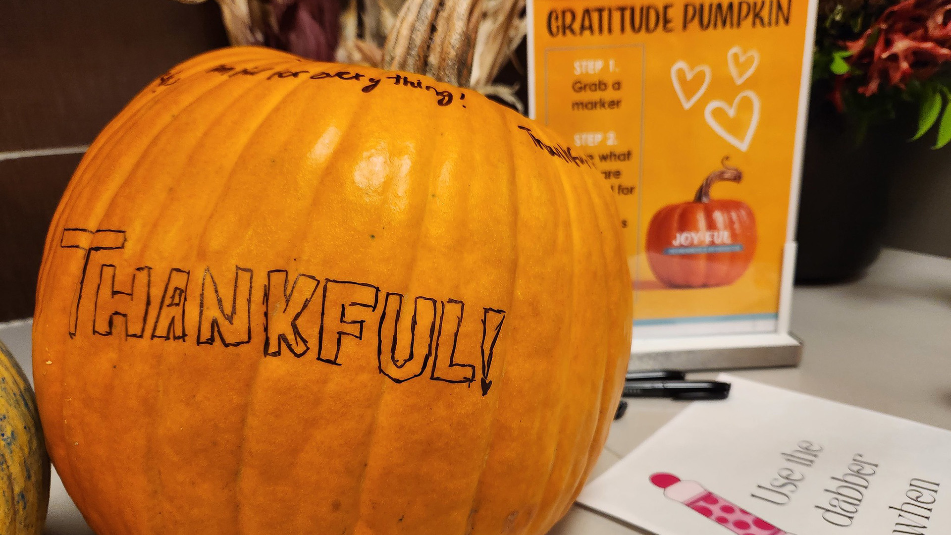 A pumpkin with Thankful on it.