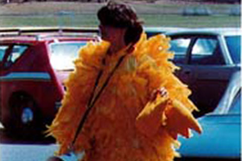A student wearing a bright yellow feather mascot costume in 1975