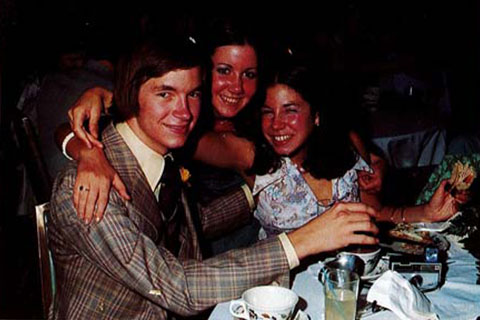 Three students seated at a table in formal dress in 1975