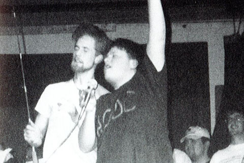 1995 student with  microphone singing on stage