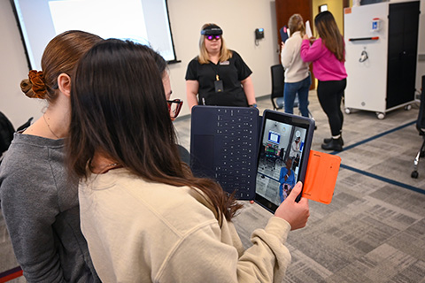 Nursing students practice skills with a patient avatar using augmented reality in a simulation class.