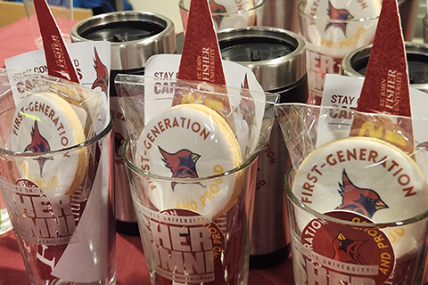 Cups filled with stickers, cookies, and pennants rest on a table.