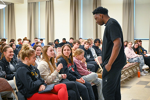 A mental health advocate speaks with students on campus.