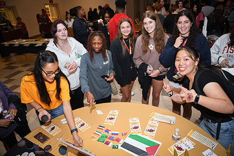 Students visit a table at the inclusion dinner.