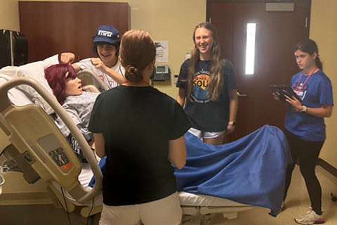 A student practices nursing skills in a simulation space.