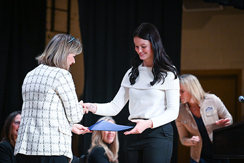 Dr. Tricia Gatlin presents a certificate to a nursing student graduate.