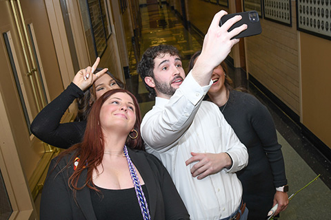 Graduating nursing students stand close to take a group selfie.