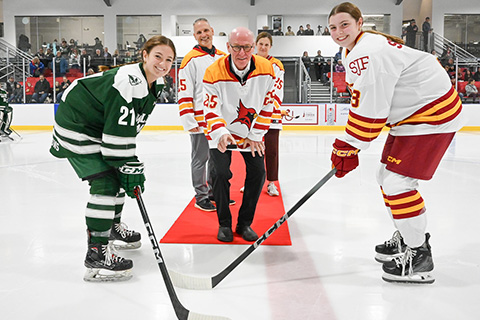 Dr. Rooney prepares to drop the puck for the womens ice hockey opening game.
