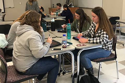 Students working on iPads in a classroom.