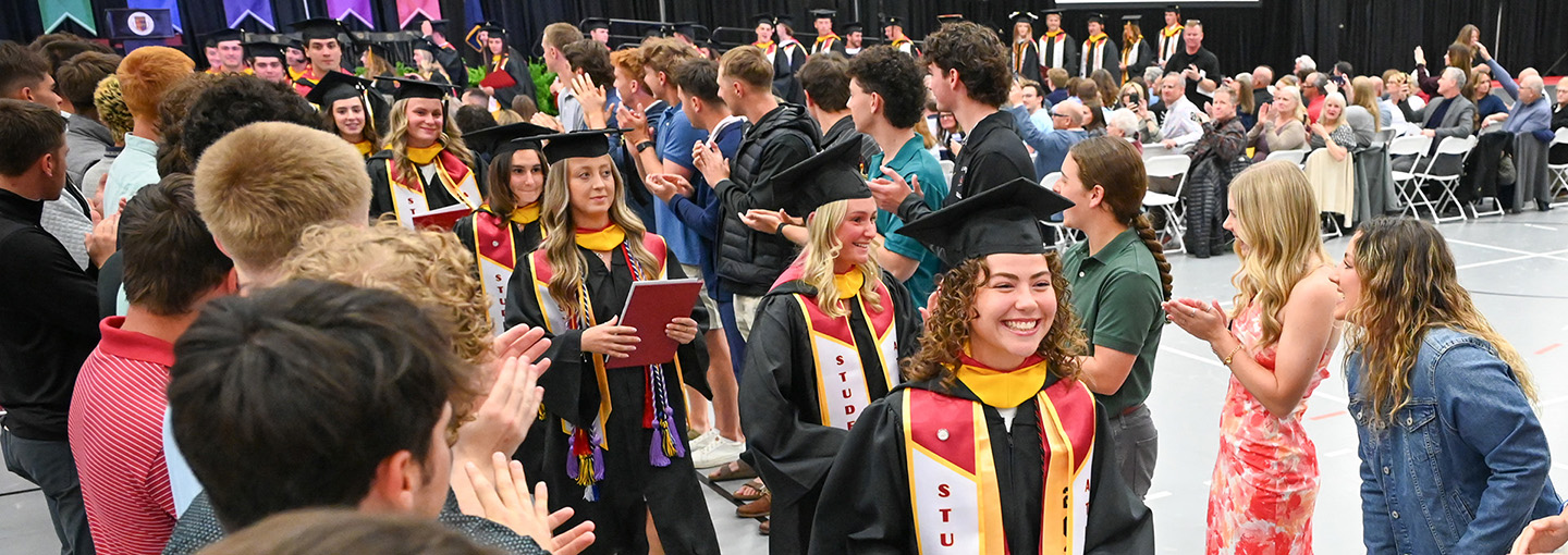 Students process in commencement regalia during a graduation ceremony.