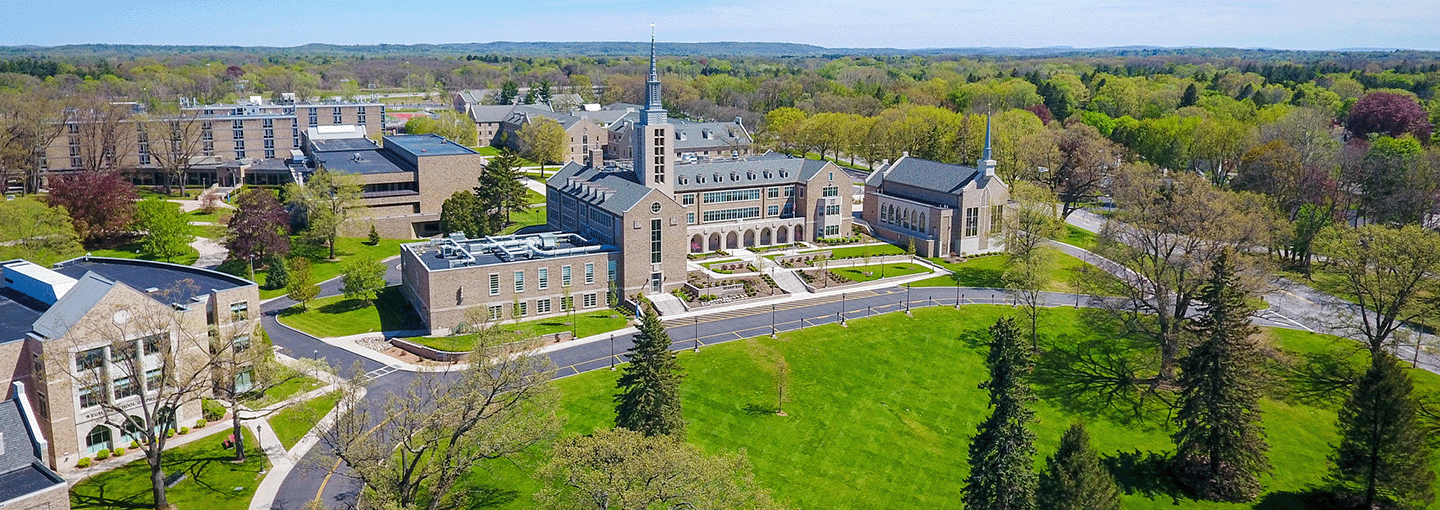 Aerial view of St. John Fisher University in spring with iconic Kearney Hall with steeple in the forefront.