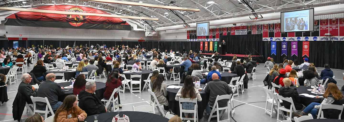 Special event at Fisher Athletic Center with several people seated at tables.