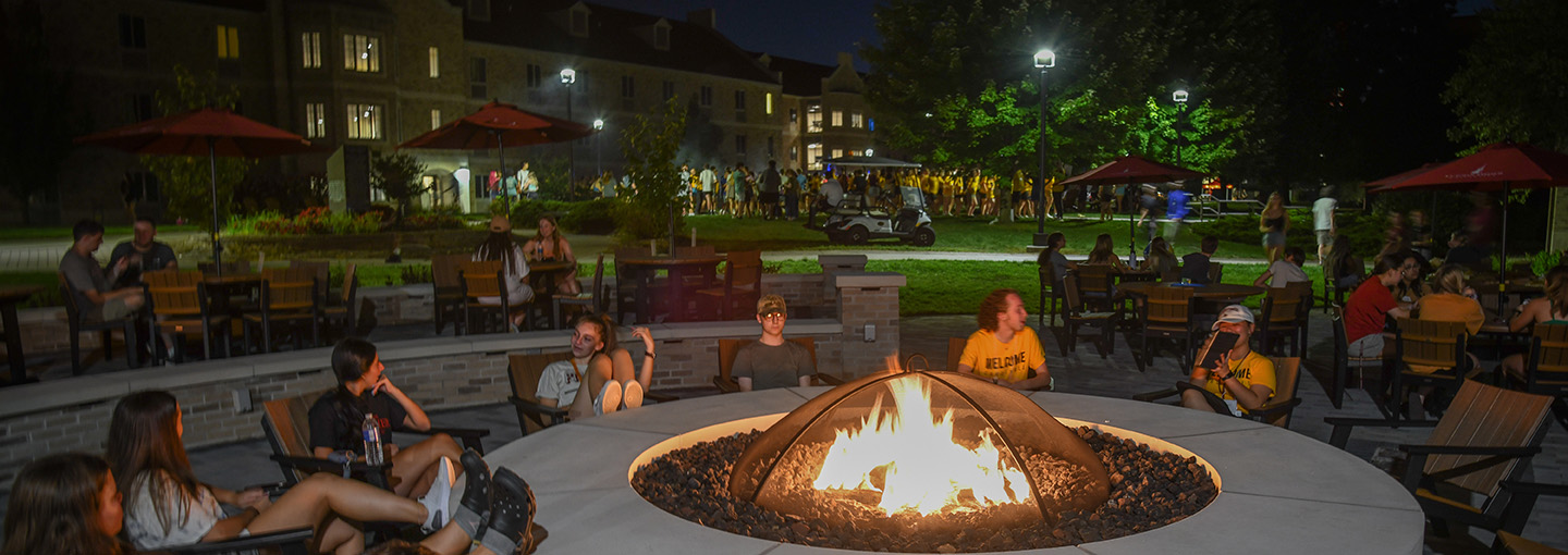Students sit around the firepit at the Terrace at Tepas Commons