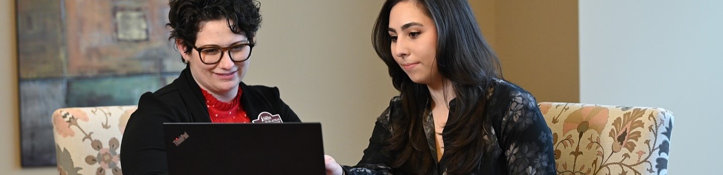 Nursing student with professor sitting with laptop