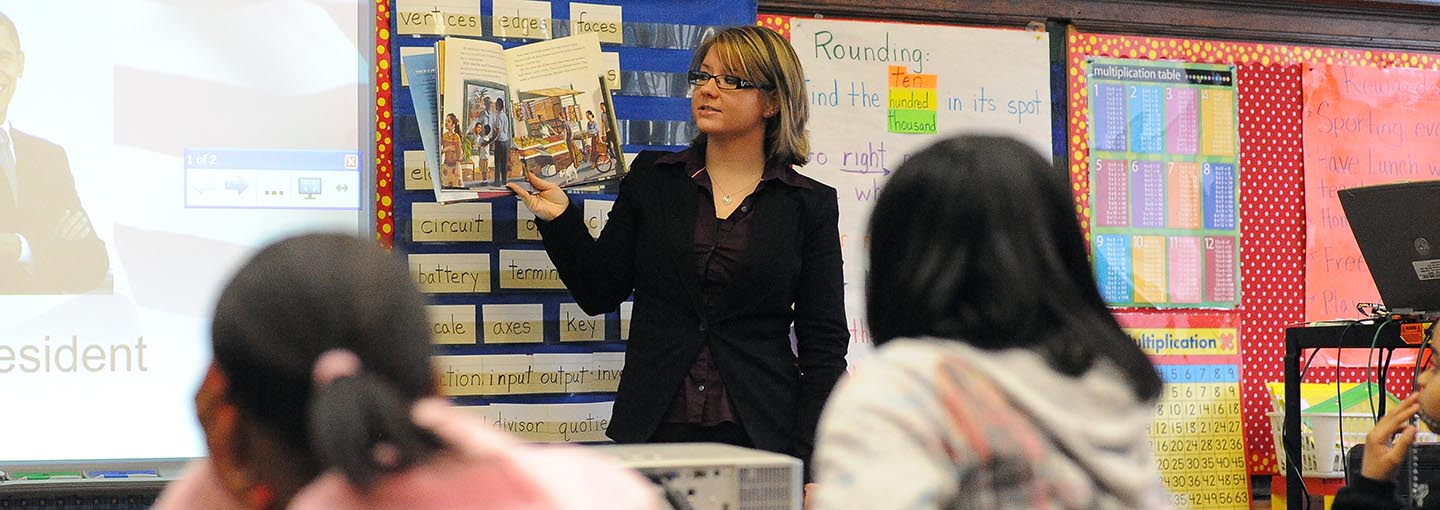 Student teacher reading at front of classroom