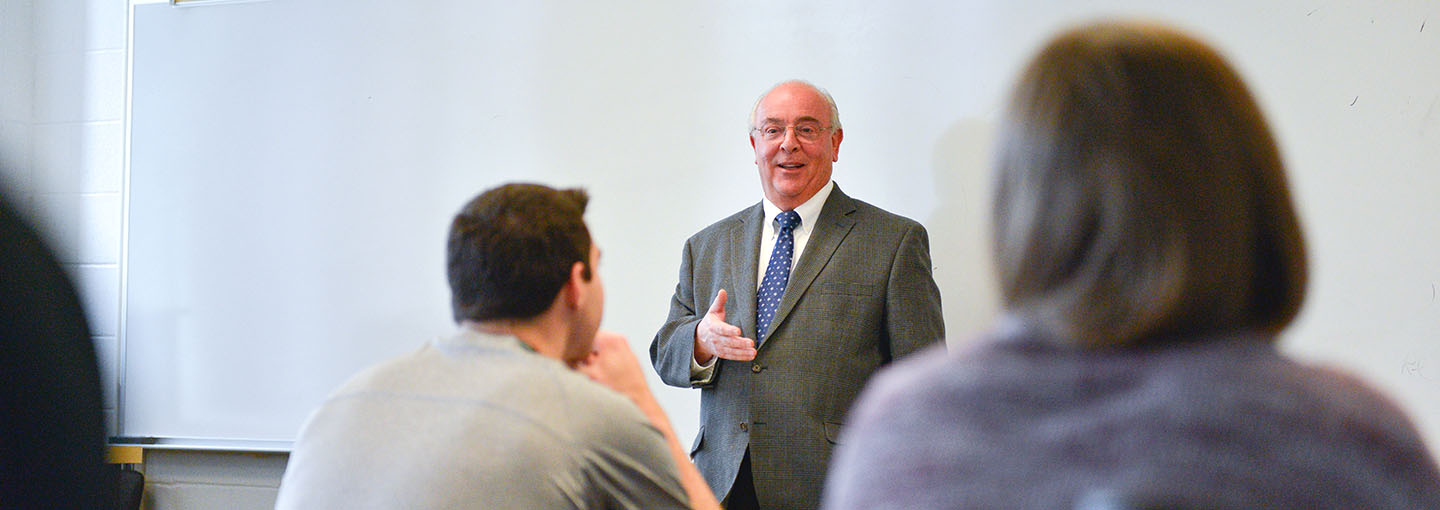 Dr. Bain teaching in front of classroom.