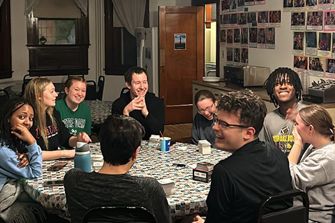Students build community around a table while on a campus ministry trip.