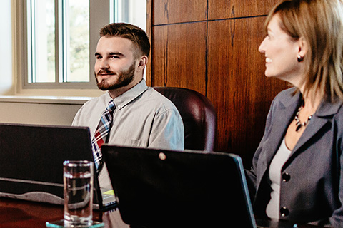 MBA students sit together in a board room.