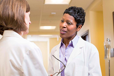 A healthcare administrator talks with another healthcare professional.