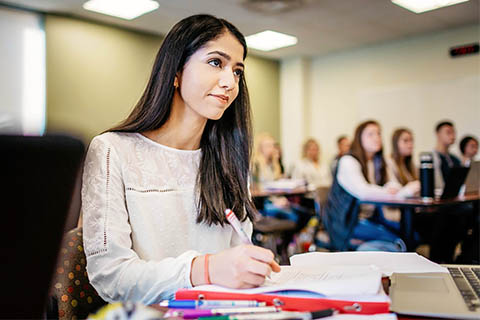 A student takes notes in class.