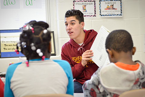 Student-athlete reading to children.