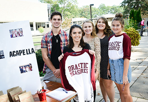 Members of Fisher's a capella group, Drastic Measures, at their Involvement Fest table.