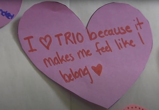 A student writes on a heart-shaped paper about why they love TRIO Student Support Services: because they feel like they belong.