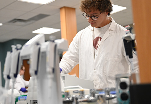 A student conducts an experiment in a chemistry lab.
