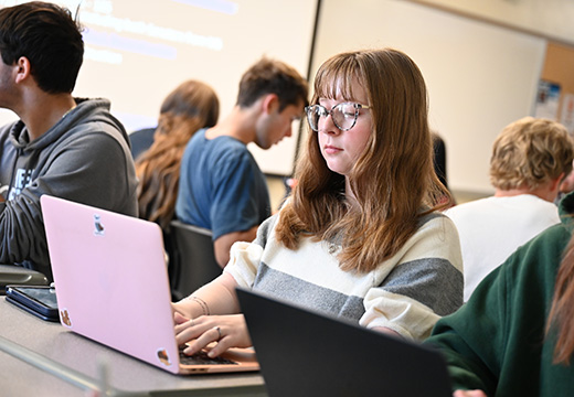 A student working on a laptop in class.