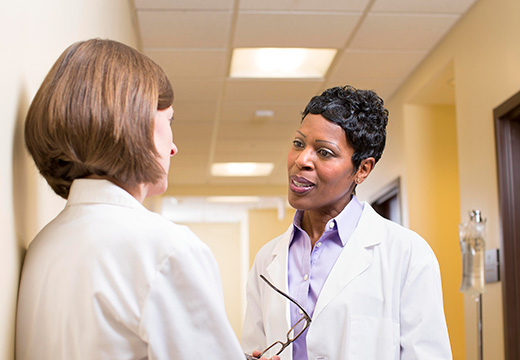 Healthcare administrators work together in the hallway of a hospital.