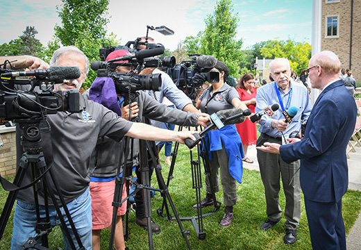 Members of the press interview Dr. Rooney at a press conference at St. John Fisher University.
