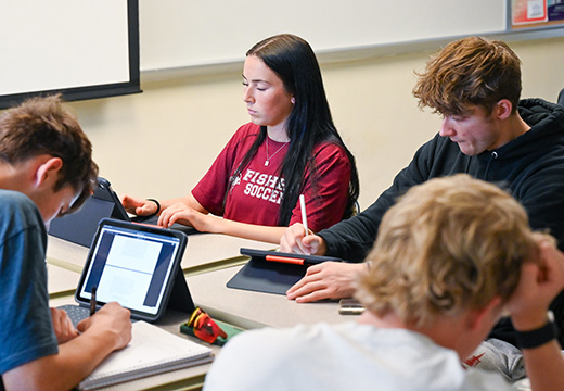 Students in classroom studying political science with iPads.